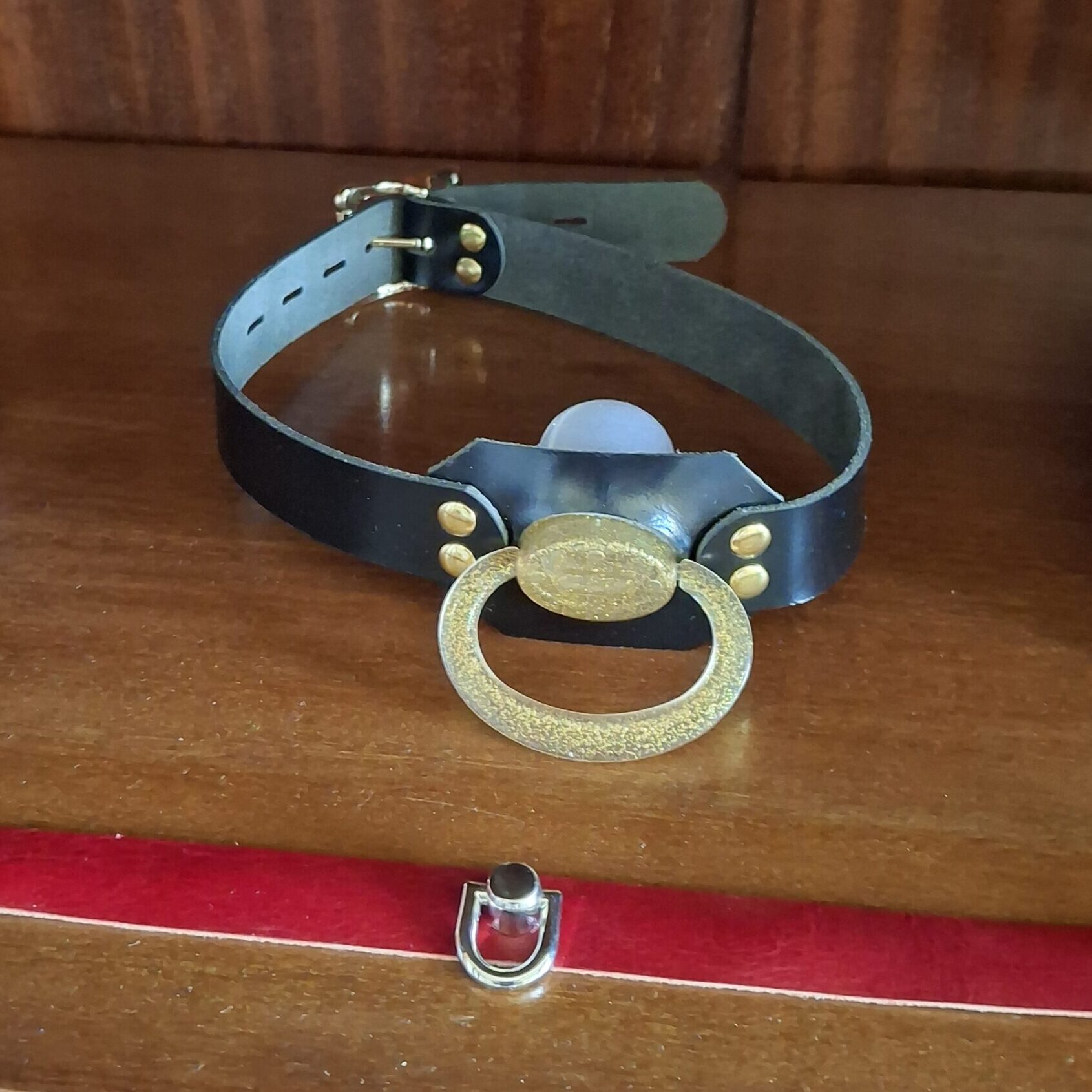 Blue leather strap with a blue pacifier shield and gold ring in the doodoo showroom.