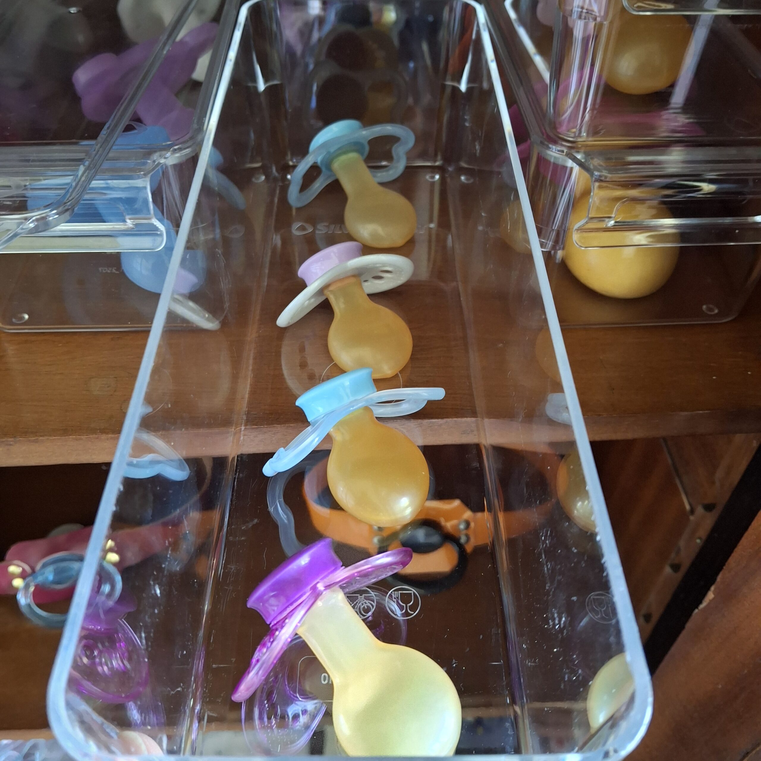 Latex pacifiers with white, blue and purple shields in the doodoo showroom.