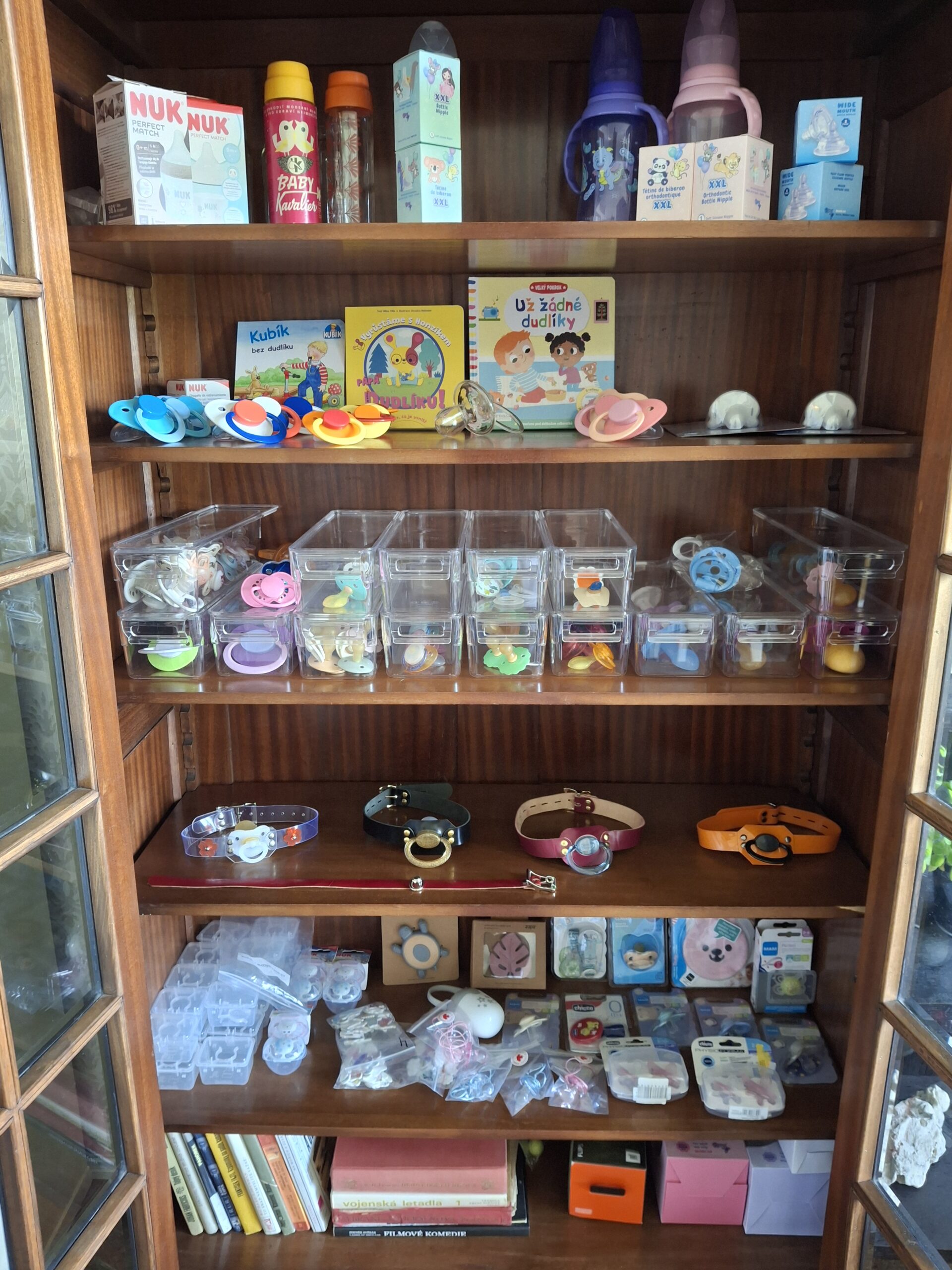 Showroom in Kladno: an open cabinet displaying pacifiers, bottles and accessories.